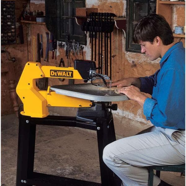 Une personne utilise une scie à chantourner DEWALT dans un atelier, avec divers outils accrochés au mur en arrière-plan. Le visage de la personne est flouté pour préserver la confidentialité.