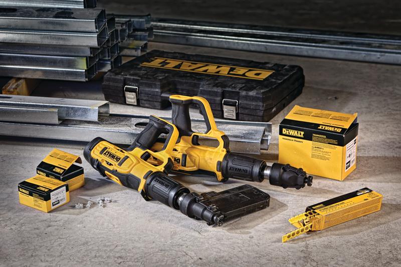 Un ensemble d'outils DEWALT DFD270SK, comprenant deux systèmes de fixation à poudre jaune et noir, une mallette de transport DEWALT, des boîtes de fixations et des poutres en acier sur un sol en béton.